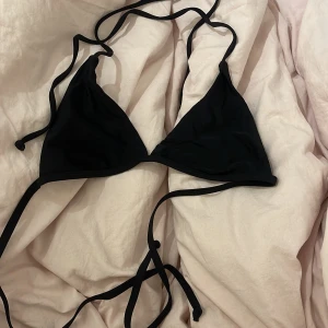 Svart bikini med knytband - Aldrig använd! Snygg svart bikini överdel i trekantsmodell med knytband i nacken och ryggen. Har ”hål” där man kan stoppa in vaddering om man vill❤️Står storlek M men skulle mer säga att den är xs/s❤️