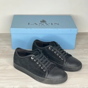Lanvin Skor - Hej! Svarta Lanvin-sneakers i mocka med gummiklädd tå, storlek 41. Bra skick, men viss användning syns. Originalförpackning ingår.  Hör av dig vid eventuella frågor!
