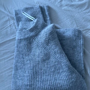 Grå stickad tröja - Säljer en mysig grå stickad tröja med ribbad design. Tröjan har långa ärmar och en rund halsringning, perfekt för kyligare dagar. Passar bra till både jeans och kjol.