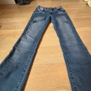 Lågmidjade jeans - Mörkblåa Lågmidjade utsvängda jeans med coola fickor. Aldrig använda. Midjemått:33cm tvärs över. Innerbenslängd: 78 cm. Är storlek W25 och skulle säga att de Passar 32/34