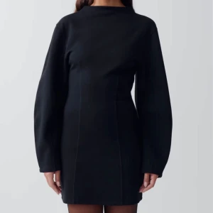 Funnel neck dress, GinaTricot  - Elegant svart klänning med långa ärmar och en figurnära passform. Klänningen har en diskret dragkedja i ryggen och en stilren design som passar perfekt för en chic look.