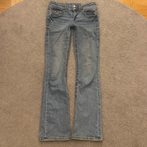 Blå bootcut jeans från Gina Tricot - Snygga blå bootcut jeans från Gina Tricot. De har en klassisk femficksdesign och stängs med dragkedja och knappar💕