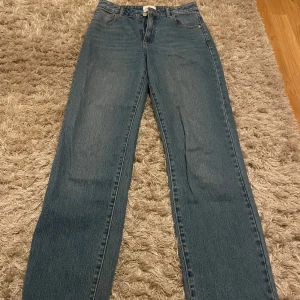 Blå jeans från Abrand Jeans - Snygga blå jeans från Abrand Jeans med klassisk femficksdesign och knappgylf. De har en rak passform och är perfekta för en avslappnad stil. Märkesdetalj på bakfickan ger en extra touch.