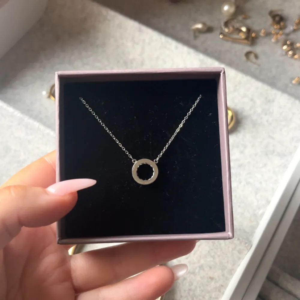 Elegant silverhalsband med en enkel cirkelberlock. Perfekt för att lägga till en subtil touch av stil till din outfit. Kedjan är tunn och smidig, vilket gör den bekväm att bära hela dagen.. Asusteet.