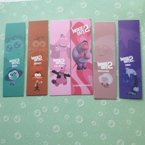 Inside Out 2 Bokmärken - Säljer ett set med sex färgglada bokmärken från Inside Out 2. Varje bokmärke har en unik känsla representerad av en karaktär, inklusive avund, ångest, nostalgi och mer. Perfekt för att hålla koll på dina favoritböcker med stil!
