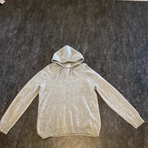 Grå hoodie - Säljer en stilren grå hoodie med långa ärmar och en klassisk huva. Perfekt för en avslappnad look. Den är mjuk och bekväm, idealisk för kyligare dagar. Det är en Kashmir från Ahlqvist clothing 