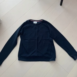 Svart långärmad tröja  - Säljer en stilren svart långärmad tröja. Tröjan har en rund halsringning och är perfekt för en avslappnad look. Är i storlek 40 men liten i storlek så passar mig som har S/M