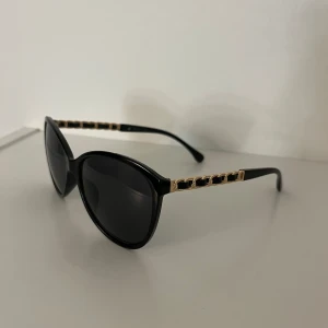 Svarta solglasögon med gulddetaljer - Svarta lite större solglasögon med gulddetalj 