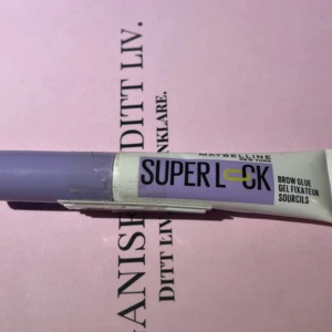 Ögonbrynsgel Super Lock från Maybelline  - Säljer en ögonbrynsgel Super Lock från Maybelline. Den kommer i en praktisk tub med lila lock och är perfekt för att fixera och forma dina bryn hela dagen. Enkel att applicera och ger ett naturligt resultat. Oöppnad produkt. Försegling finns på produkt. Säljer för 100 kronor