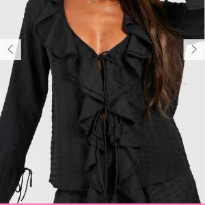 Svart blus med volanger - Svart volangblus med knyte. Säljer pga att den inte kommer till användning, använd ca 5 gånger och därav i jättebra skick!! Storlek M men passar S också 