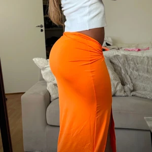 Kjol med detalj - Sååå härlig orange kjol med snygg detalj på sidan och en slit. Sitter som en dröm ☄️🌺 storlek XS