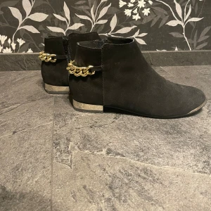 Svarta klackskor med guld detaljer - Säljer svarta skor med liten klack med dragkedja med guld detaljer och dragkedja i storlek 39. Jag har fått dom så vet jag inte hur mycket dom är använda men sulan är lite lite sliten men inget som påverkar. Annars inga defekter. Köparen betalar frakten!