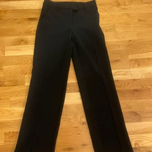 Svarta kostymbyxor - Snygga svarta kostymbyxor med hög midja och rak passform. Byxorna har en diskret dragkedja och knapp framtill. Perfekta för en stilren look. Dom är knappt använda🥰 orginal pris 500