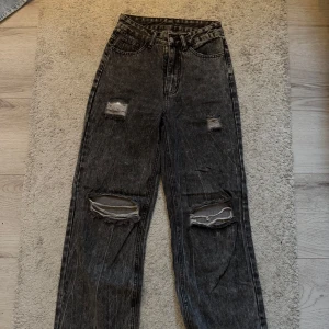 Svarta jeans med slitningar - Coola svarta jeans med slitningar på knäna och låren. De har en hög midja och en straight passform som ger en avslappnad look. Köptes för länge sen, så dem passar fy är inte längre! Jeansen är från SHEIN men är jätte fin kvalité !