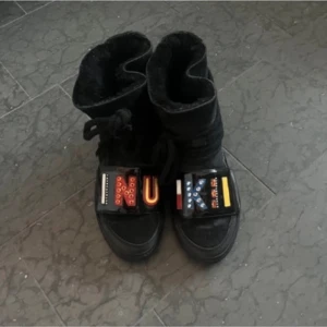 Svarta boots med dekorativa detaljer - Inuikii svarta med snörning och dekorativa bokstäver i olika färger på framsidan. 