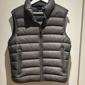 Ralph Lauren väst - Snygg grå dunväst från Ralph Lauren. Storlek Large passar S, stilren och inge defekter skicket är 9/10. Nypris 2500kr mitt pris 699kr