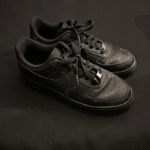 Svarta Nike sneakers - Hej! Jag säljer nu mina svarta Nike air Force 1. Perfekta för en stilren look. Skorna har en diskret Nike-logga på sidan och perforerade detaljer på ovansidan 💗dom är använda fåtal gånger 