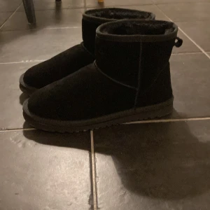 Svarta uggs skor  - Säljer ett par svarta UGG boots i mocka. De är varma och perfekta för kyligare väder med sin mjuka insida.