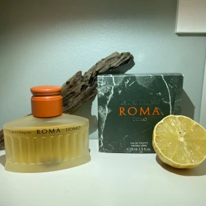 Laura Biagiotti Roma Uomo EDT - Upptäck den eleganta och maskulina doften av Roma Uomo från Laura Biagiotti. Denna Eau de Toilette kombinerar fräscha citrusnoter med träiga och med en perfekt amber, vilket ger en kryddig och varm känsla. Perfekt för den moderna mannen som vill utstråla självsäkerhet och stil. Ca 70/75ml kvar