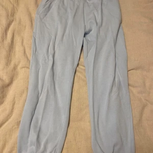 Ljusblå mjukisbyxor - Säljer ett par ljusblå mjukisbyxor från 157 i storlek L. De är superbekväma och perfekta för en chill dag hemma eller en snabb tur till affären. Byxorna har en elastisk midja med snöre för perfekt passform💙