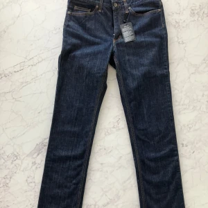 Mörkblå jeans från GANT - Snygga mörkblå jeans från GANT i modellen 'Dawn'. De har en normal passform och är tillverkade i ett klassiskt denimtyg. Perfekta för en stilren look med sina raka ben och midwaist-design. Nypris ligger på 1400kr som man ser på bilden, de är helt nya. 