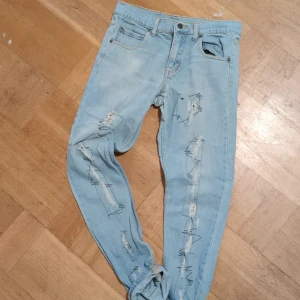 Ljusa jeans från Cheap Monday, orginell sicksack tråd.  - Säljer ett par ljusa jeans från Cheap Monday med slitna detaljer och en cool, avslappnad look. Perfekta för en trendig stil. De har en klassisk femficksdesign och knappgylf.