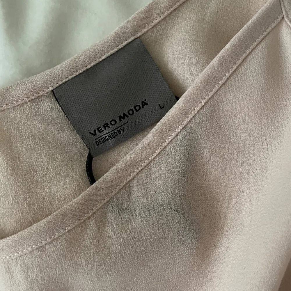 Säljer en stilren beige linnetopp från Vero Moda. Toppen är ärmlös med smala axelband och har en enkel, elegant design. Perfekt för sommardagar eller som ett basplagg i garderoben. Passar både till vardags och festliga tillfällen.. Toppar.