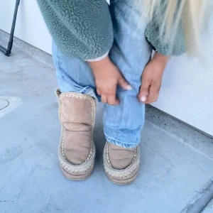 Mou skor - Lägger upp igen pga oseriösa köpare. 💗Säljer ett par mysiga beige MoU boots med stickade detaljer runt kanterna. Perfekta för kalla dagar med sin varma och bekväma design. Pris prutbart vid snabb affär. 🩷Strl 37 men passar snarare som 38. Nyskick med både låda och lappar kvar!💘