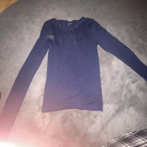 Mörkblå långärmad topp från Gina Tricot - Säljer en snygg mörkblå långärmad topp från Gina Tricot i storlek XS. Perfekt för både vardag och fest. Toppen är i bra skick och har en enkel men stilren design. Passar perfekt till jeans eller kjol! 