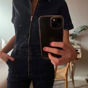 Mango byxdress i jeans - Säljer en snygg mörkblå jeans jumpsuit från MNG i storlek XS. Den har korta ärmar och en dragkedja framtill. Perfekt för en casual look eller en utekväll. Jumpsuiten har en figurnära passform och praktiska fickor. Köptes nypris ca 700kr (använd en gång) 💙