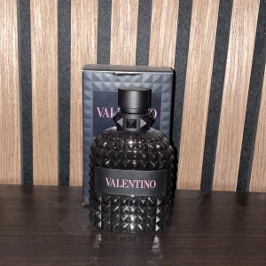 Valentino Uomo Born in Roma - Säljer en lyxig parfymflaska från Valentino, modellen Uomo Born in Roma. Flaskan är svart med ett coolt nitat mönster och har en elegant svart kork. Perfekt för den som vill ha en stilren och modern doft på hyllan. Kommer i originalförpackning. Den var från början 100 ml men det finns ungefär 87-92 ml kvar✅ Nypris: 1300 mitt pris: 799