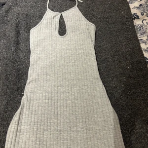Grå klänning - Säljer denna gråa ribbade klänning med knytning i nacken💕