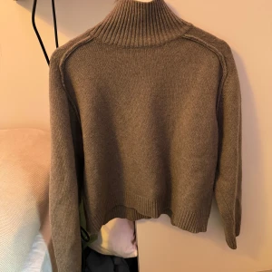 Beige stickad polotröja - Mysig beige stickad polotröja med ribbad krage och långa ärmar. Perfekt för kyliga dagar och ger en stilren look. Passar bra till både jeans och kjol. Från H&M i bra skick.
