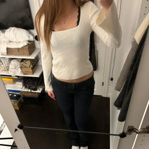 Vit ribbad tröja från Vila - Säljer en stilren vit ribbad tröja från Vila. Tröjan har en fyrkantig halsringning och långa ärmar, perfekt för en chic vardagslook. Storlek S!