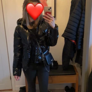 Svart pufferjacka från Calvin Klein  - Snygg svart pufferjacka från Calvin Klein med glansig finish. Jackan har en dragkedja framtill och långa ärmar. Perfekt för kyligare dagar med sin stilrena design och varma material. Inköpt för 2000kr i storlek 14år men skulle säga att den är en xs💗