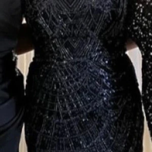  Marinblå glittrig klänning - Elegant marinblå klänning med glittrigt mönster. Perfekt för festliga tillfällen med sin figurnära passform. Endast använd ett par timmar, priset går att diskutera!