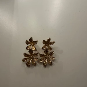Guldiga blommiga örhängen - Säljer ett par superfina guldiga örhängen i form av blommor.