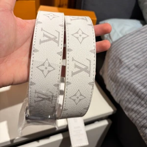 Vit märkesbälte - Säljer ett snyggt vitt bälte med det klassiska. Bältet har ett stilrent silverfärgat spänne  Perfekt för att ge din outfit en lyxig touch. Kommer i originalförpackning. Passar både till vardag och fest!