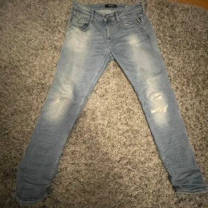 Billiga Replay Anbass jeans!! - Säljer ett par billiga Replay Anbass jeans i ljusblått.  As feta med lite slitningar på framsidan.  De är i superbra skick och har en normal passform. Säljer för att de är för långa för mig. Perfekta för både vår och sommar! Nypris 1200 typ. Hör av er vid frågor
