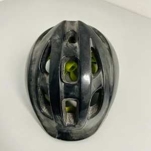 Svart och vit cykelhjälm - Säljer en svart och vit cykelhjälm i mycket bra skick. Hjälmen har en justerbar passform med gula detaljer på insidan för extra komfort. Perfekt för cykling och andra utomhusaktiviteter. Skydda huvudet med stil!