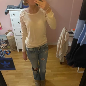 Vit tröja med spetsdetaljer - Säljer en superfin begie/vit tröja med långa ärmar och snygga spetsdetaljer på axlarna. Perfekt för både vardag och fest! Tröjan är i bra skick och passar perfekt till jeans eller kjol. Skön och stilren design som funkar året runt. 🌟