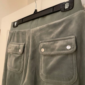 Mjukisbyxor Juicy Couture  - Säljer mina gröna mjukisbyxor från Juicy Couture. Knappt använda. Men har tyvärr fallit av en metallgrej till byxorna som syns på sista bilden, försvunnit i tvätten. Annars i skick som nytt! 