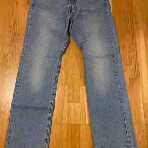 Levis 501 jeans i blått - Säljer ett par klassiska Levis 501 jeans i blått. De har en straight passform och är i mycket bra skick. Perfekta för både vardag och fest. Midwaist och tillverkade i slitstarkt denim. Ett måste i garderoben för den som älskar tidlös stil!