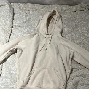 Vit hoodie från BIK BOK - Säljer en stilren vit hoodie från BIK BOK i storlek XS. Den har en klassisk design med känguruficka och justerbar huva med dragsko. Perfekt för en avslappnad look. 🕶️