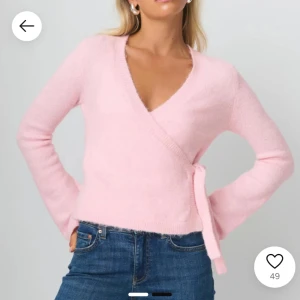 Rosa omlottkofta - Söt rosa omlottkofta med knytband i midjan. Tröjan har en v-ringad design och långa ärmar, perfekt för en mysig och stilren look. Aldrig använd. Säljes till lite högre pris då Gina inte säljer denna färg mer. Skriv för fler frågor!🌸