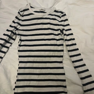 Randig ribbad tröja - Säljer en stilren randig tröja med svart och vit design. Tröjan är ribbad och har långa ärmar, perfekt för en avslappnad look. Passar bra till både jeans och kjol.
