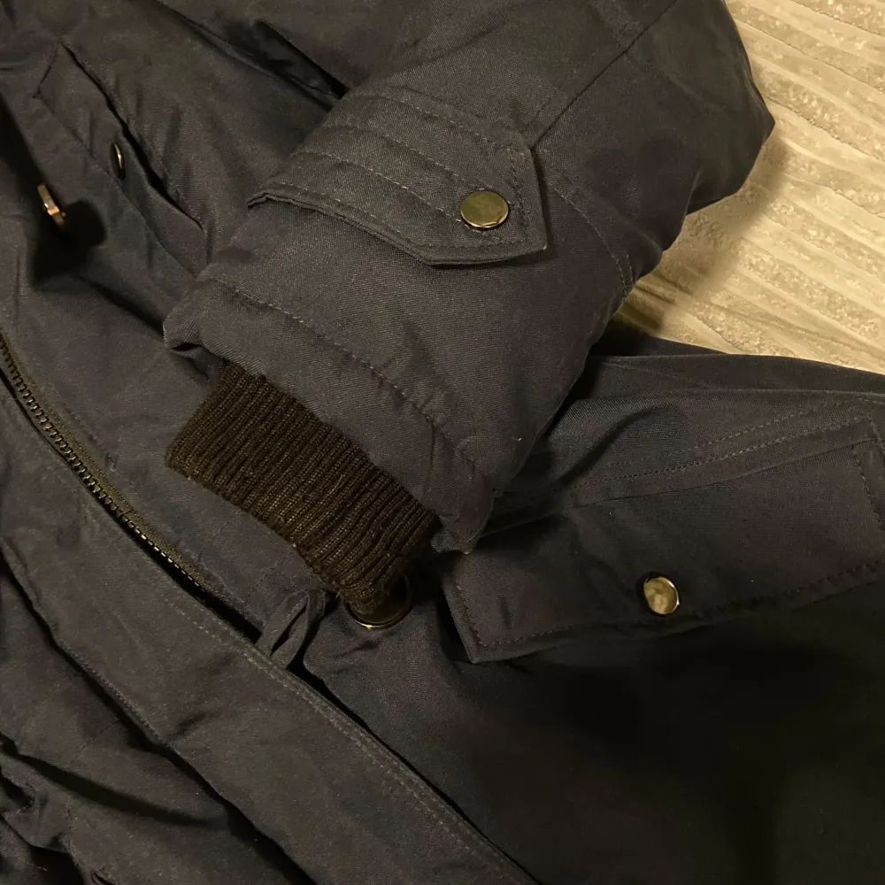 Snygg svart parkajacka från Vero Moda med fuskpäls på huvan. Jackan har dragkedja och knappar framtill samt praktiska fickor. I bra skick ☺️. Takit.