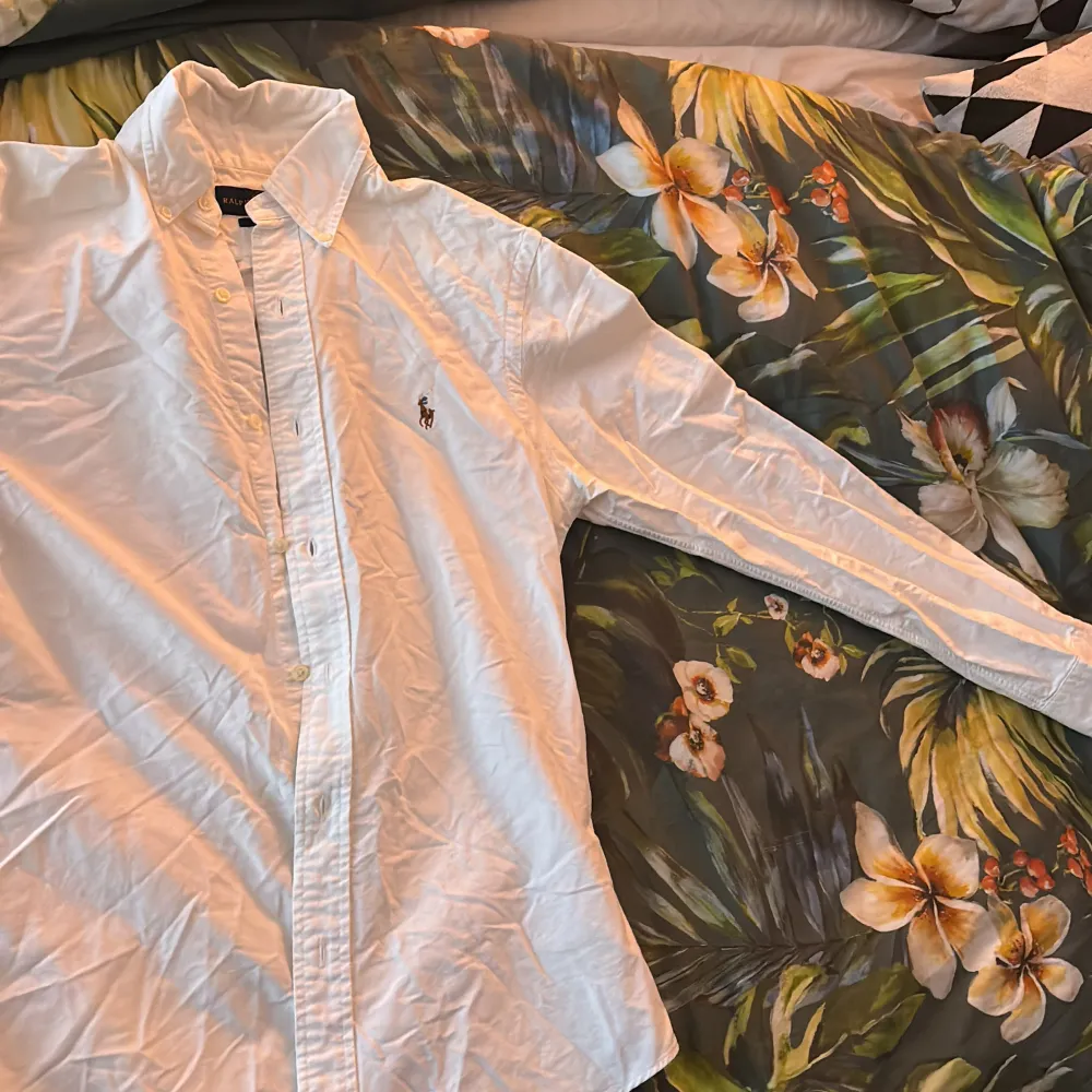 Mitt i flytt så tyvärr inget strykjärn! Säljer en klassisk vit skjorta från Ralph Lauren med broderad logga på bröstet. Skjortan har en slim fit passform och är långärmad med knappar hela vägen ner. Perfekt för en stilren look.. Paidat.