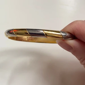 Tvåfärgat armband i guld och silver - Snyggt och stilrent armband i både guld och silver. Designen är enkel men elegant med en vriden look som ger en modern touch. Perfekt för att lyfta vilken outfit som helst. Okänd metall 