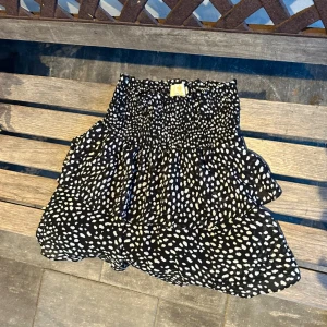 Svart och vit prickig kjol från Chelsea - Säljer en söt svart och vit prickig kjol från Chelsea i storlek XS. Kjolen har elastisk midja. 